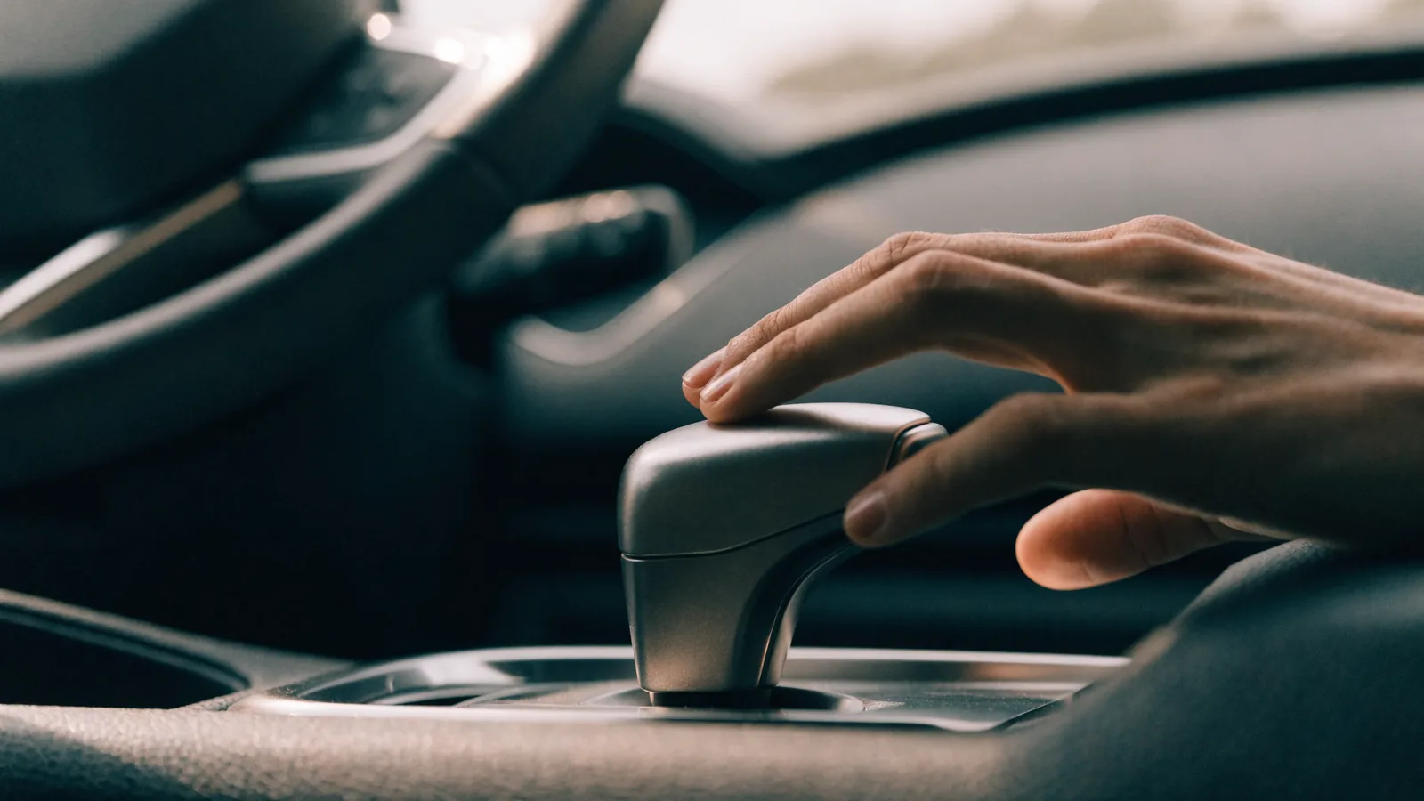 Mão do motorista sobre o seletor de um câmbio automático